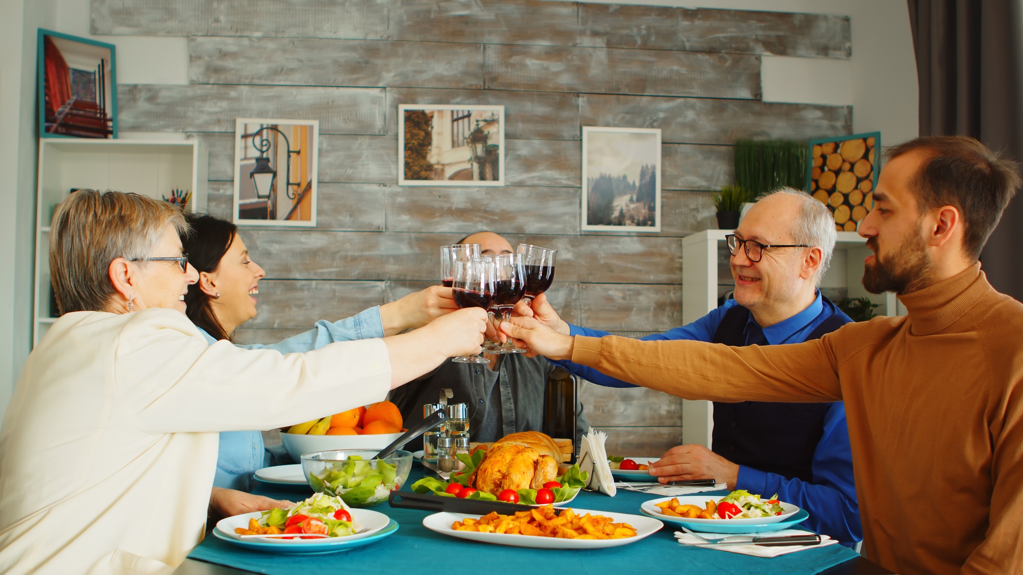Happy family during lunch toasting with red wine