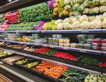 View of vegetable counter in supermarket. Fruits and vegetables on store stand in supermarket