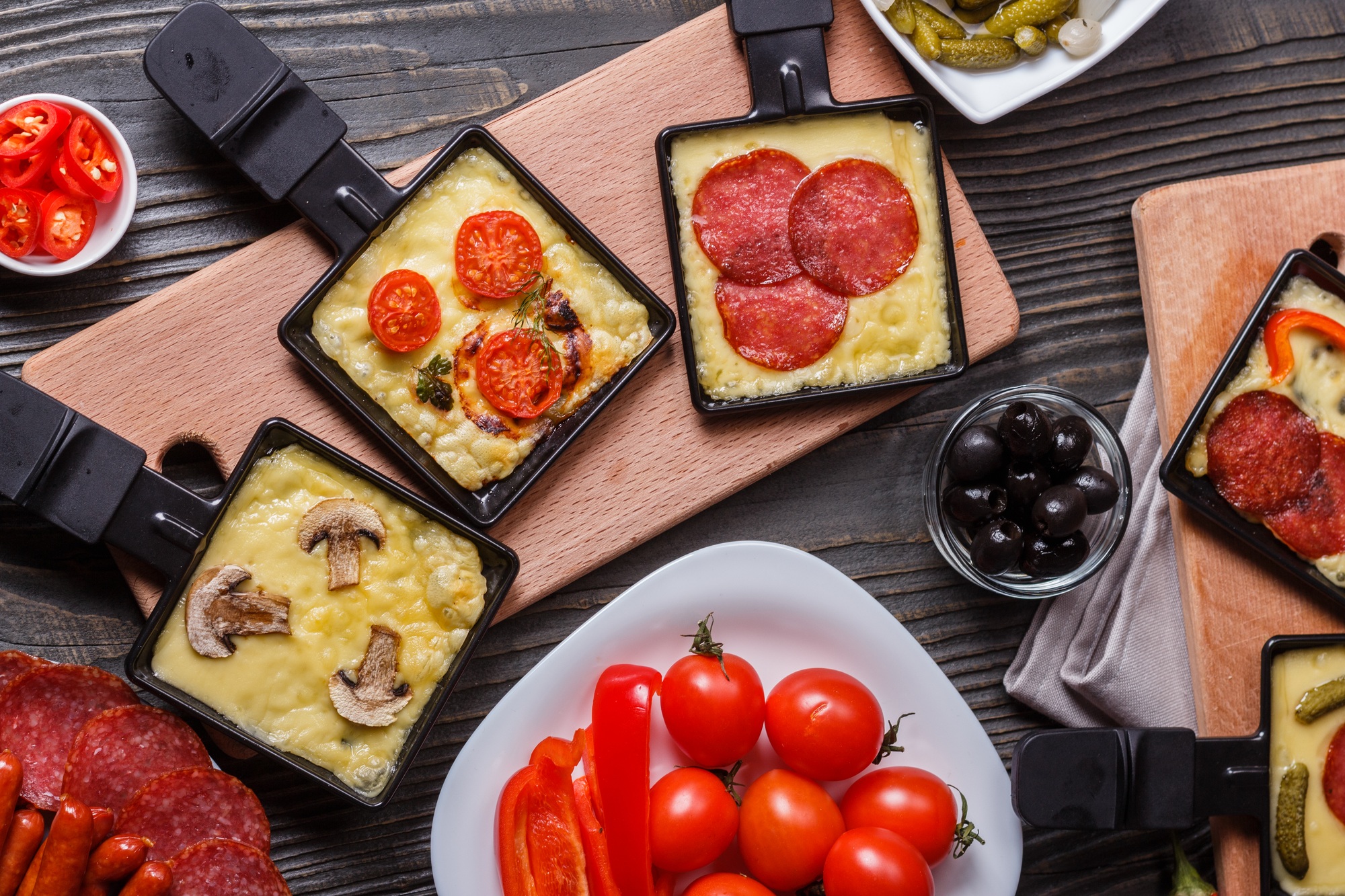 young woman is preparing a traditional Swiss cheese raclette